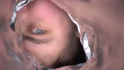 A young man looks suspiciously into an empty bag of chips. First-person view of Video stock 233937760