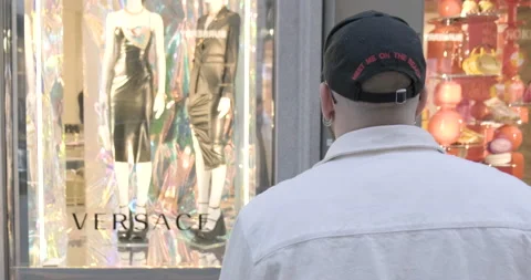 Young man looks at the Versace window display, Milan, Italy Stock Footage 172535488