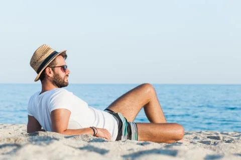 Young man lying on the beach Stock Photos