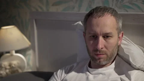 Young man lying in the bed with laptop before sleeping Stock Footage 161561762