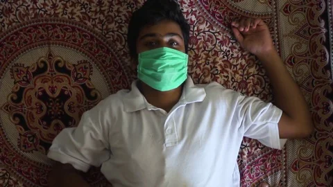 Young man lying on bed with mask on corona virus bacteria air pollution Video stock 127677028