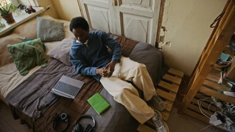 Young Man Lying in Bed, Resting and Working on Laptop from Apartment Stock Footage 334798577