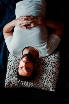Young man lying in bed thinking Stock Photos