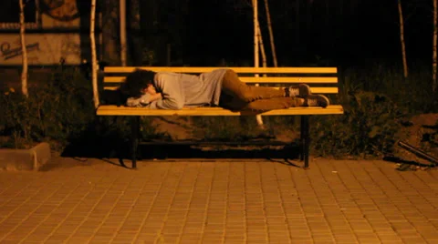 Young man lying on a bench. Video stock 32847050