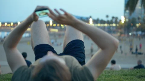 Young Man Lying Browsing Social Network on Beach Stock Footage 118931343