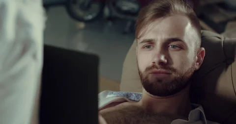 Young man lying on the couch reads a book, isolation during a pandemic. covid 19 Stock Footage 145431924