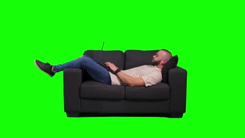 Young man lying down on sofa, using laptop and relaxing Stock Footage 136369631