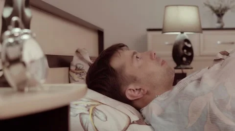 Young man lying in his bed is frightened Stock-Footage 68429523