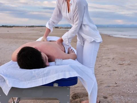 A young man lying on a massage table receiving a chiromassage treatment on the Stock Photos