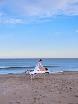 A young man lying on a massage table receiving a chiromassage treatment on a Stock Photos
