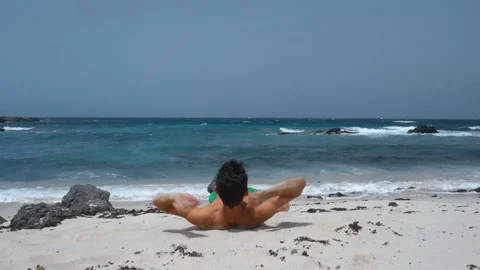Young man lying on the shore of the beach. Orzola. Stock Footage 136825135