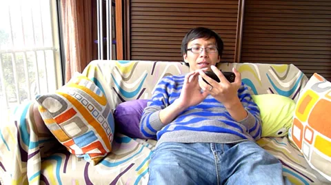 Young man lying in the sofa and playing smartphone games,failing with depression Stock Footage 36457342