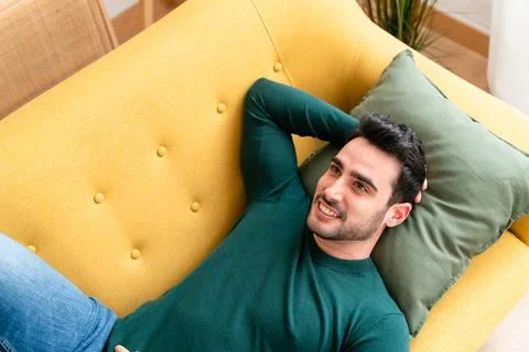Young man lying on sofa Stock Photos