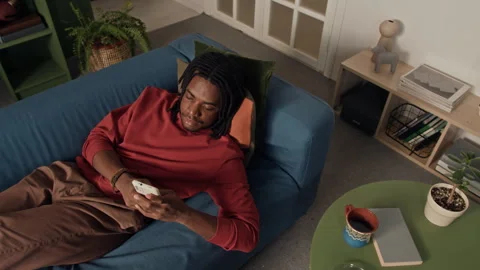 Young Man Lying on Sofa Sending Voice Messages while Teleworking from Home Stock-Footage 328252870