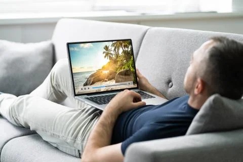 Young Man Lying On Sofa Watching Video Stock Photos