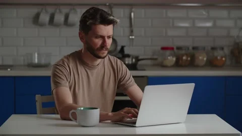The young man made coffee and sat down at his laptop. A yawning man works Stock Footage 238922335