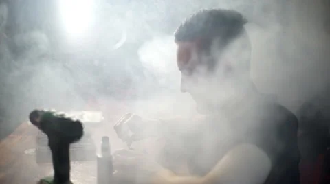 Young man make a coil build on RDA in smoky vape shop Stock Footage 64234457