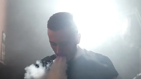 Young man make a coil build on RDA in smoky vape shop Stock Footage 64234561