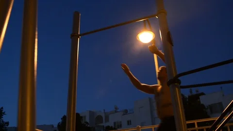 Young man make morning pull ups, in low ligths of street 스톡 동영상 91427676