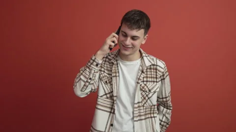 Young man make a phone call on mobile phone talk studio shot Stock Footage 300789764