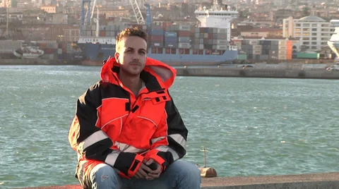 Young man make telephone call in port with orange clothes. Stock Footage 32263129