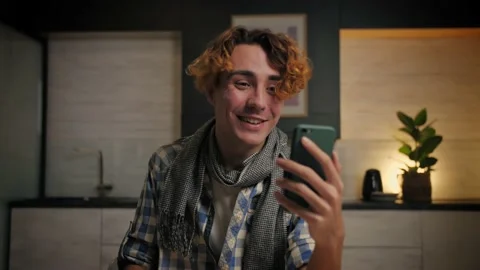 Young Man make video call using smartphone at home.Guy doing online Stock Footage 221618829