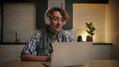 Young Man make video call using laptop at home.Guy with headphones doing online Stock Footage 221619191