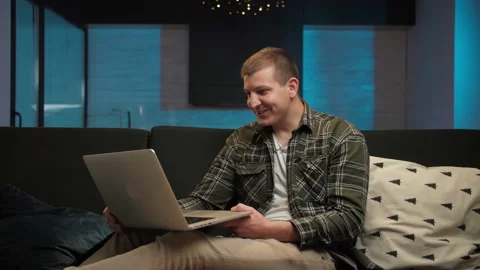 Young Man make video call using laptop sitting at home interior.Smiling guy Stock Footage 225656136