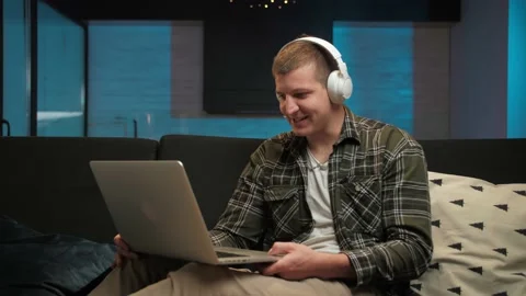 Young Man make video call using laptop sitting at home interior.Smiling guy with Stock Footage 225657192