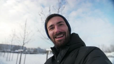 Young Man make video call using phone looking at camera winter snow nature Stock Footage 225934489