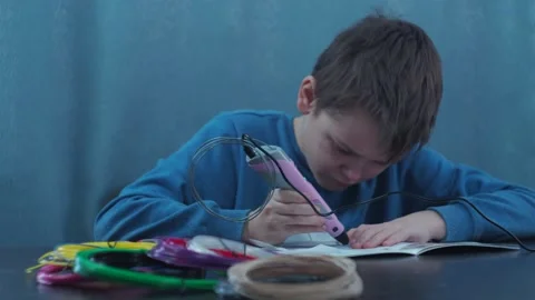 A young man makes a 3 d model with a pen. model made of plastic wire Stock Footage 146794156