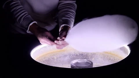 A young man makes cotton candy, in the evening in the park. Stock Footage 221304503