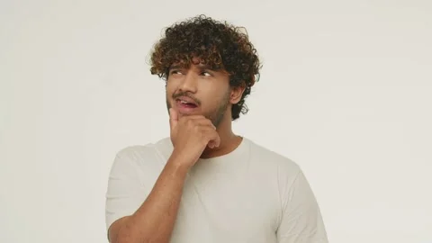 Young man makes a difficult choice. Confused male model thinking about problem Stock Footage 231475825