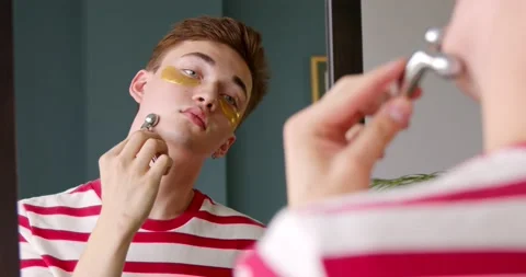 Young man makes face massage with a massager roller Stock Footage 149329146