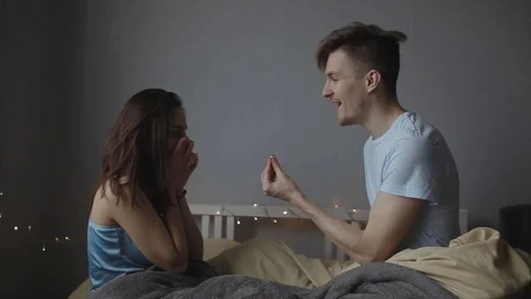 A young man makes an offer to his girlfriend in bed, and she agrees Stock Footage 103150555