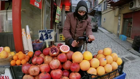 Young man makes pomegranate juice on the street of Istanbul and sells it - Wide Stock Footage 155173854