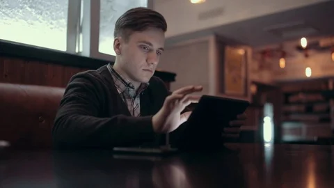 A young man makes a purchase in the online store using the tablet Stock Footage 71565460