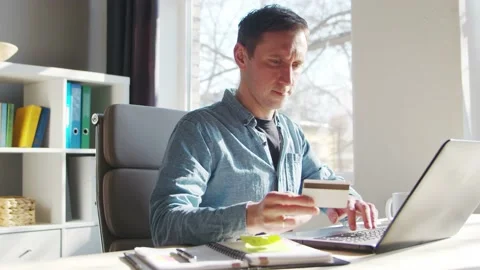 Young man makes purchases on the Internet using a bank credit card. The person Stock Footage 172489759