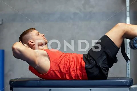 Young man making abdominal exercises in gym Stock Photos