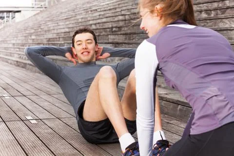 Young man making abs exercises outdoors with coach Stock-Fotos