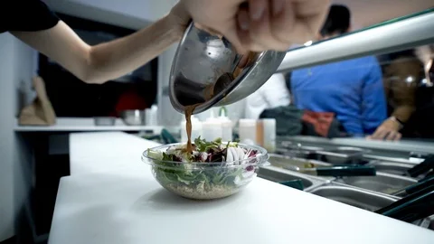 Young man making an ahi tuna poke bowl with rice, prawns, tofu and veggies Video stock 128927793