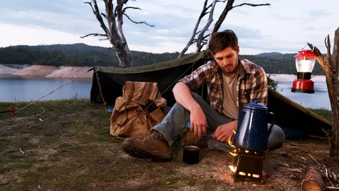 Young Man Making Coffee on a Camp Fire Stock Footage 127189587