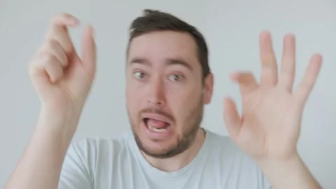 Young man making a dramatic and exaggerated expression with raised hands Stock Footage 306260028