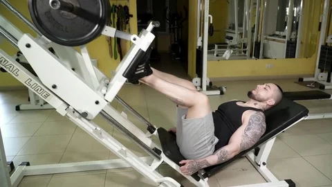 Young man making exercises on the leg press in the gym Stock Footage 74136854