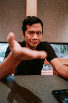 Young man making inviting gesture with outstretched hand Stock Photos