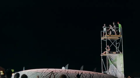 Young Man Making a Jump From a Springboard to to the Big Airbag Night. Slow Stock Footage 60681495