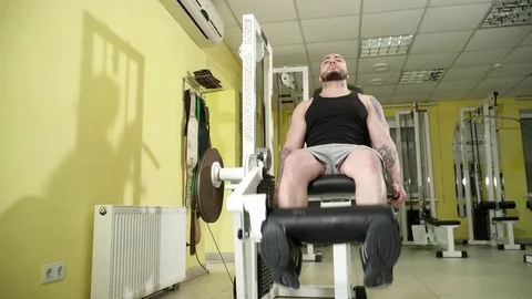 Young man making leg extensions exercises Stock Footage 74135227