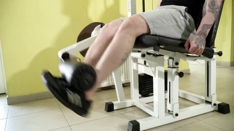 Young man making leg extensions exercises closeup Video stock 74135262