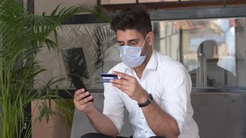 Young man making online payment using smartphone during pandemic. Stock Footage 146301231