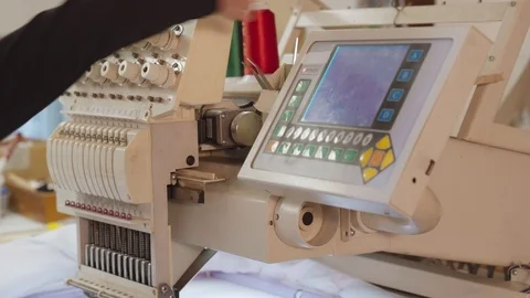 Young man making ornament on computerized embroidery machine Stock Footage 89343487